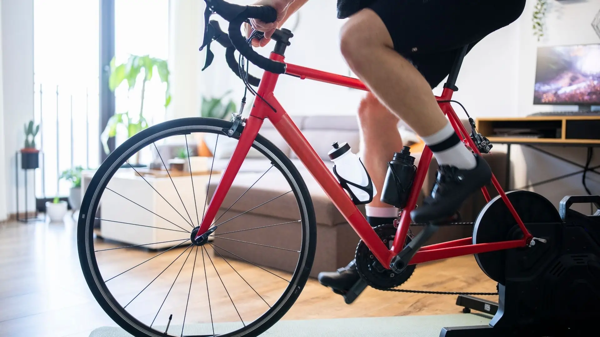 Kolarz korzystający z trenażera rowerowego